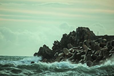 Rocks on beach against sky