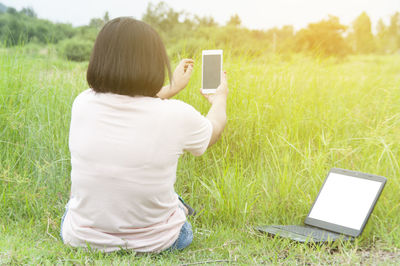 Rear view of girl standing on grassy field