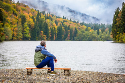 Rear view of woman standing by lake