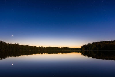 Scenic view of lake against sky at night