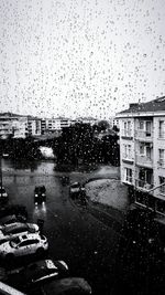 Buildings seen through wet glass window in rainy season