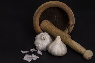 Close-up of garlic on table against black background