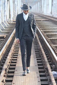 Full length of a man walking on railroad tracks