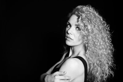 Portrait of woman against black background