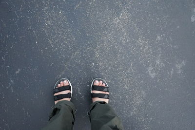 Low section of person standing on road in city