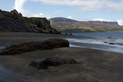 Rocks on beach against sky