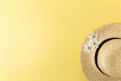 Close-up of hat against yellow background