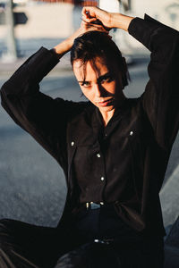 Young man looking down while sitting outdoors