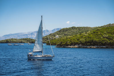 Sailboat sailing on sea against sky