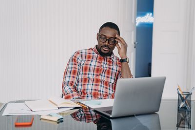 Portrait of man using laptop while sitting on table