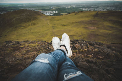 Low section of woman relaxing on rock