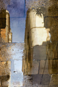 Reflection of old building on puddle