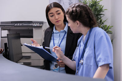 Portrait of doctor examining patient in hospital