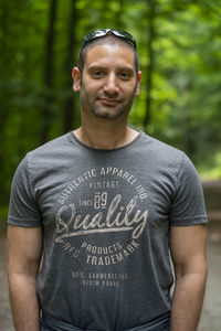 Portrait of smiling man standing against tree