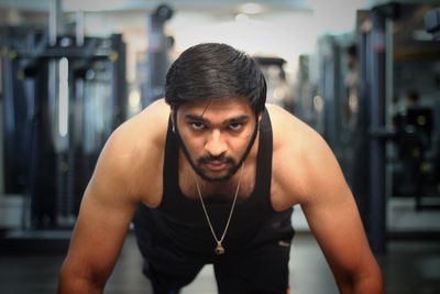 Portrait of young man exercising in gym