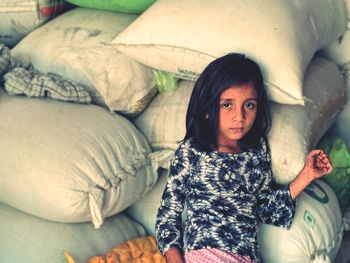 Portrait of girl sitting on sacks