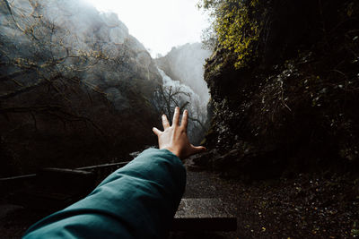 Midsection of man on rock in forest