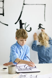 Boy and girl caligraphing chinese signs