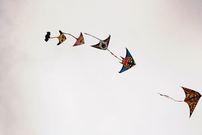 Low angle view of flags flying against clear sky