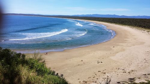 Scenic view of beach against blue sky