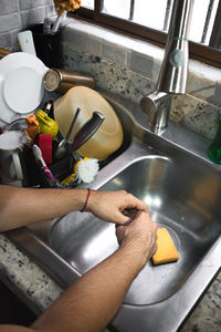 Midsection of woman holding camera at home