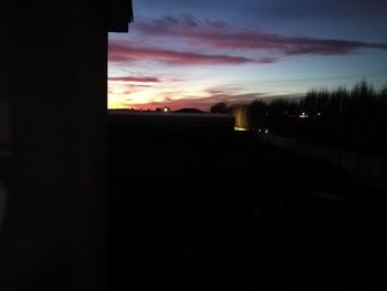 Silhouette buildings against sky at sunset