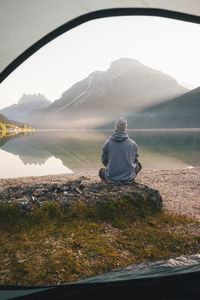 Rear view of woman looking at lake against mountain