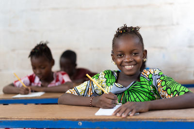 Portrait of a smiling girl sitting on table