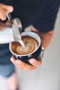 Midsection of man preparing coffee in cafe