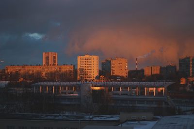 Buildings in city against sky at sunset