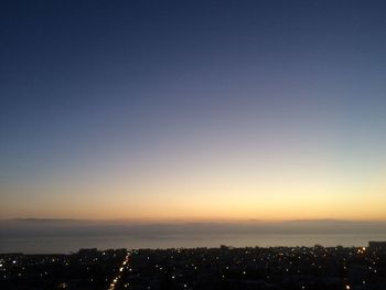 Aerial view of illuminated cityscape against clear sky at night