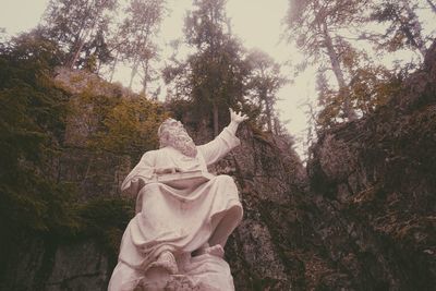 Low angle view of statue against trees