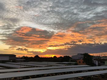 Houses and buildings against sky during sunset