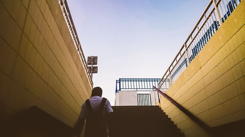 Rear view of man walking on steps