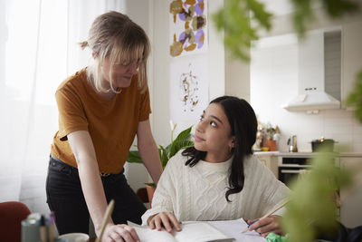 Mother assisting to girl doing homework