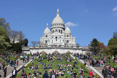 Tourists at basilique du sacre coeur against sky