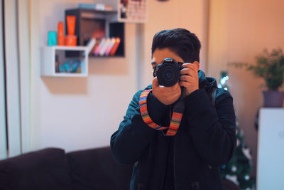 Full length of man photographing at home