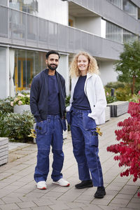 Male and female worker in front of residential building