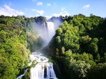 Scenic view of waterfall against sky