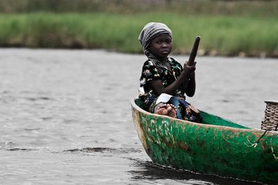 Full length of man sitting on boat in river