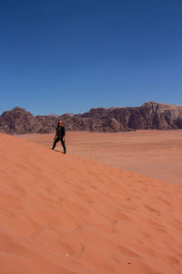 Full length of man on desert against clear sky