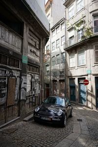 Abandoned car in front of building