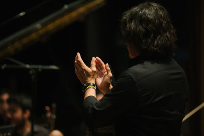 Side view of man applauding