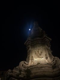 Low angle view of illuminated statue against sky at night