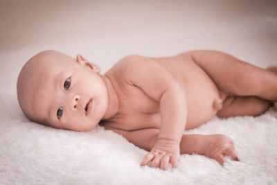 Portrait of baby lying on bed