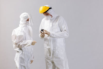 Rear view of female doctor standing against white background