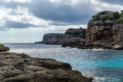 Rock formations by sea against sky