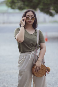 Young woman wearing sunglasses standing outdoors