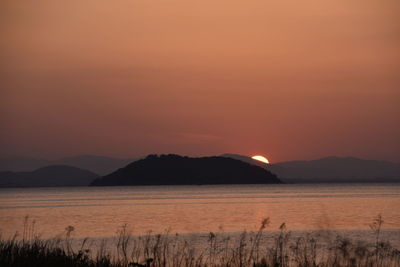 Scenic view of sea against romantic sky at sunset