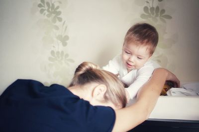 Mom playing with cute baby boy at home